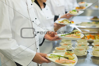 Chef holding salmon dishes