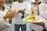 Young chefs applauding a salmon dish