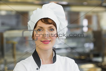 Happy female chef posing in a kitchen