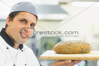 Young baker showing a loaf of bread