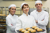 Three young bakers posing in a kitchen