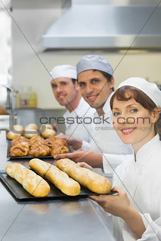 Three young bakers holding baking trays