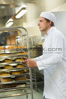 Handsome young baker pushing a trolley