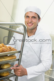 Young baker pushing a trolley with food on it