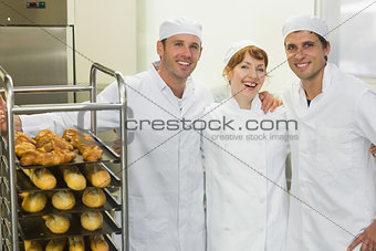 Three young bakers posing together in a bakery