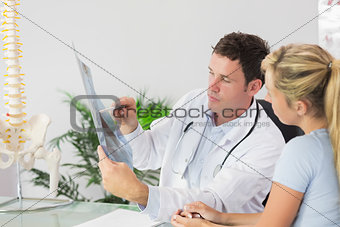 Handsome doctor showing a patient something on x-ray