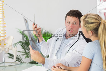 Serious doctor showing a patient something on x-ray