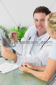 Smiling doctor showing a patient something on x-ray