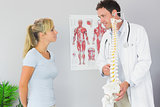 Content doctor holding skeleton and talking to patient