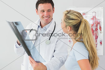 Cheerful doctor showing a patient something on x-ray