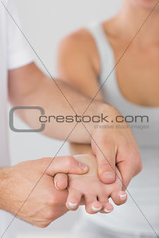 Physiotherapist examining patients hand