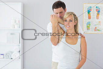 Attractive physiotherapist examining patients arm