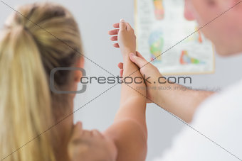 Physiotherapist checking patients arm