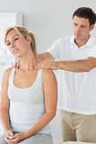 Good looking physiotherapist massaging patients neck