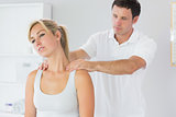 Handsome physiotherapist massaging patients neck