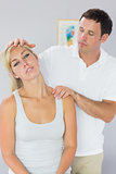 Attractive physiotherapist checking patients neck
