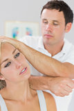 Calm physiotherapist massaging patients neck with elbow