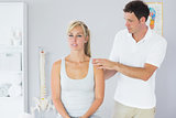 Attractive physiotherapist examining patients back