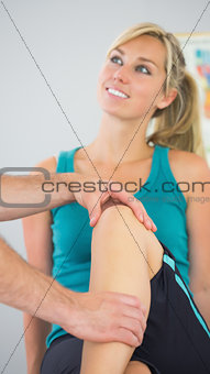 Patient having knee examined by physiotherapist