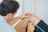 Physiotherapist checking knee with goniometer