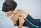 Physiotherapist measuring knee with goniometer