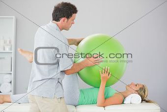 Patient training with exercise ball and physiotherapist