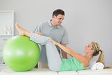 Patient holding exercise ball with legs