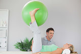 Patient holding exercise ball between legs