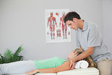 Attractive physiotherapist massaging patients neck