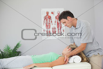 Attractive physiotherapist massaging patients neck