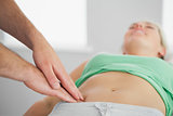 Physiotherapist pressing patients pelvis