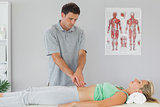 Physiotherapist examining patients pelvis