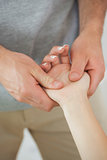 Physiotherapist examining the hand of a patient