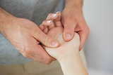 Physiotherapist checking the hand of a patient