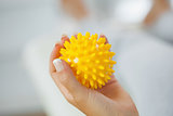 Close up of female hand holding yellow massage ball