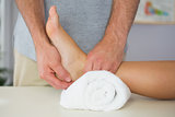 Physiotherapist checking patients foot on towel