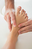 Physiotherapist kneading patients foot