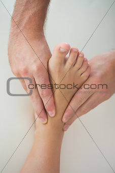 Close up of physiotherapist kneading patients foot