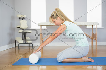 Blonde patient sitting on floor doing exercise