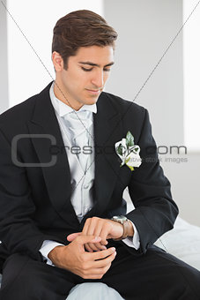 Young bridegroom watching the clock