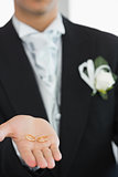 Young bridegroom showing wedding rings
