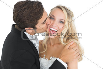 Handsome bridegroom kissing his wife on her cheek