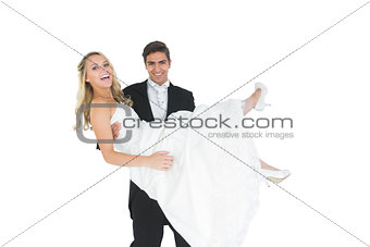 Smiling bridegroom lifting his wife up