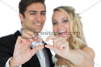 Cheerful married couple showing their wedding rings