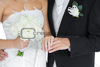 Young married couple posing holding hands