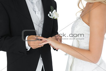 Bridegroom putting the wedding ring on his wifes finger
