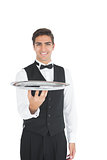 Young waiter presenting an empty tray