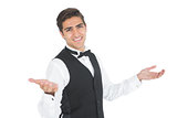 Handsome young waiter making a certain gesture