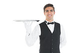 Attractive waiter presenting an empty tray