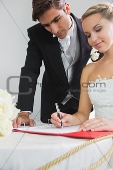 Young smiling bride signing wedding contract